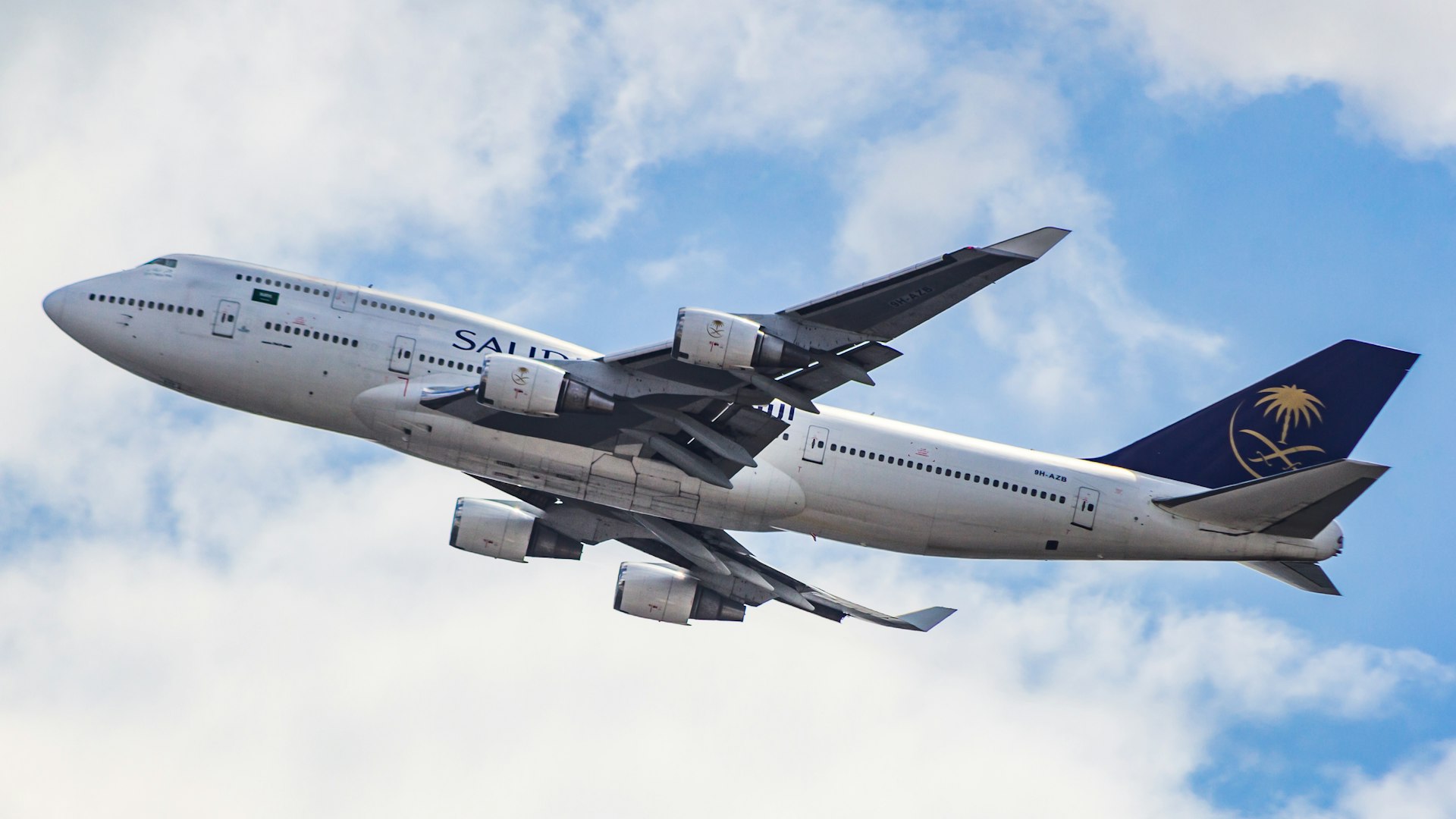 A large jetliner flying through a cloudy blue sky